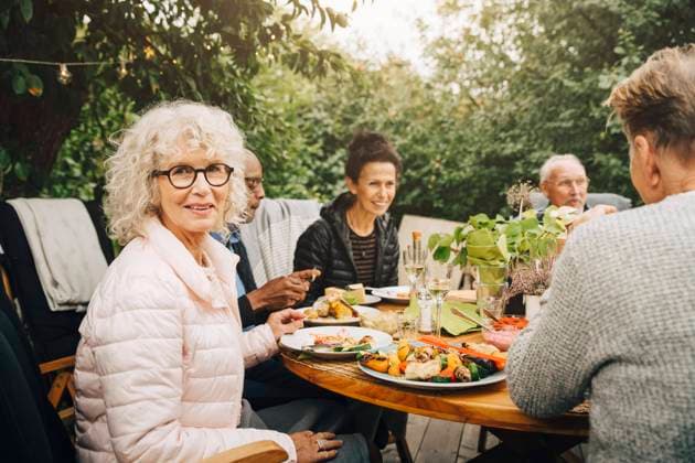Portrait of smiling senior woman sitting with friends at dining table during dinner party Sweden, Stockholm, model released, property released Copyright: xMaskotx , MA79972