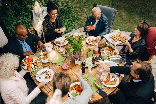 High angle view of senior male and female friends enjoying dinner at dining table during back yard garden party Sweden, Stockholm, model released, property released Copyright: xMaskotx , MA79999