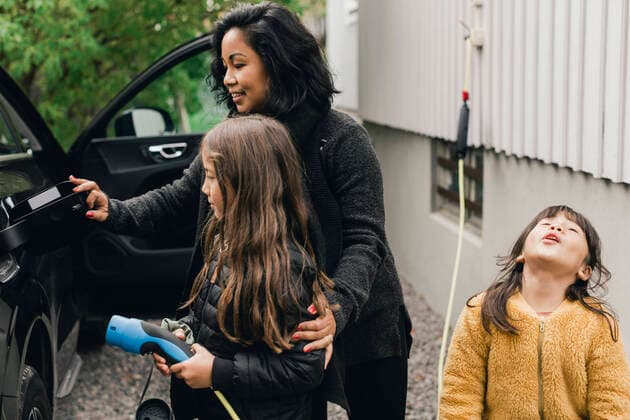IMAGO Creative: Internationaler Frauentag, Mental Load und Care-Arbeit IMAGO Creative: Klimawandel - Zukunft und Innovation Woman teaching daughter to charge electric car at charging station Sweden, Stockholm, model released Copyright: xMaskotx , MA80092