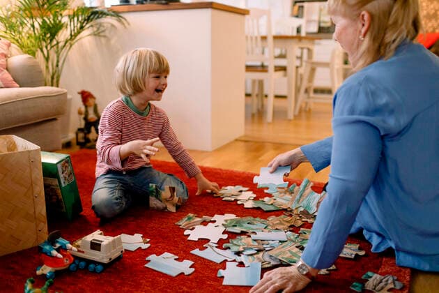 IMAGO Creative: Jahreszeit Winter, Fantasievoll drinnen spielen Cheerful boy playing jigsaw puzzle with grandmother in living room Sweden, Stockholm, model released, property released Copyright: xMaskotx , MA80215