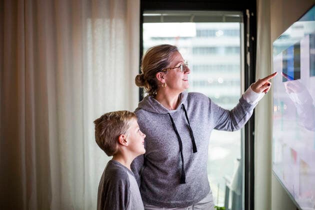 Mother guiding son in using smart TV at home Sweden, Stockholm, model released, property released Copyright: xMaskotx , MA80370