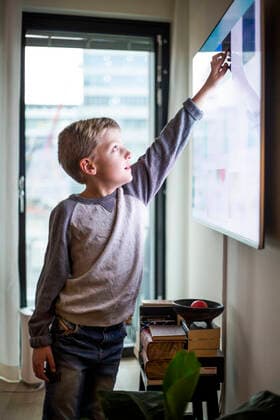 Boy touching digital display of smart television set at modern home Sweden, Stockholm, model released, property released Copyright: xMaskotx , MA80374