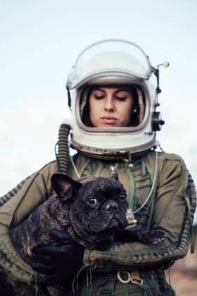 IMAGO Creative: Lokalhelden - Gesundheits- und Rettungskr?fte Girl wearing old space helmet holding a dog Copyright: xJosexLuisxCarrascosax Model Released