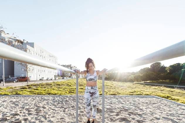 IMAGO Creative: Neue Aussichten Attractive slim lady in sportswear doing exercises on parallel bars on court near buildings Copyright: xJosexLuisxCarrascosax Model Released