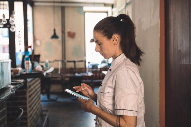 IMAGO Creative: Neue Aussichten Side view of female chef using smart phone in restaurant Germany, Berlin, model released, property released Copyright: xMaskotx , MA81464