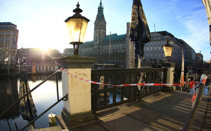 Flutter tape blocks the access to a restaurant closed during the lockdown at the Alsterarkaden In the background the Hamburg City Hall Old Town Hamburg