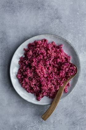 IMAGO Nature: Unsere Erde, Klimawandel, Ern?hrung, Pflanzen der Zukunft, Quinoa Top view of plate with healthy organic cooked red quinoa and wooden spoon on grey background Copyright: xLeirexGamboax Model Released