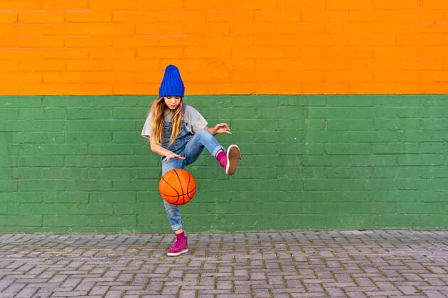 IMAGO Creative: Lokalhelden - Jugendsportbildung Young girl playing basketball, dribbling and lifting leg model released Symbolfoto ERRF01230