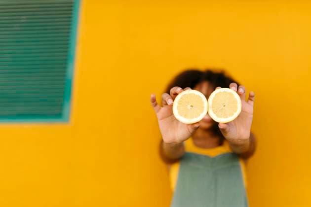 Close-up of young woman holding halved lemons model released Symbolfoto TCEF00481