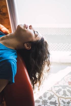 IMAGO Creative: Gesundheit, Stille Side view of pretty young female in casual outfit keeping eyes closed and leaning back while sitting on comfortable couch near window, Model released Copyright: xLuciaxVargasx MR