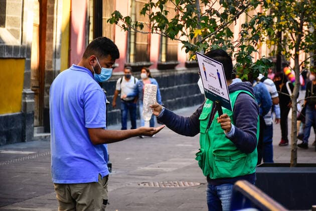 December 19, 2020, Mexico, Mexico: A member of the City government personnel provides an antibacterial gel to a man wearing a face mask in Mexico City..Claudia Sheinbaum, the mayor of Mexico City announced that the metropolitan area that includes Mexico City and the State of Mexico turned red at the epidemiological traffic light due to the increase in hospitalizations and occupancy of 78% of the hospital beds available to treat the coronavirus. The red light indicates that all non-essential activities will be restricted from December 13 to January 10. Mexico Mexico - ZUMAs197 20201219_zaa_s197_151 Copyright: xGuillermoxDiazx