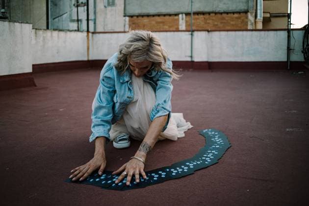 IMAGO Creative, Lifestyle, Esoterik gef?hrlicher Glaube Serious female fortune teller reading Tarot cards while sitting on roof of old building Copyright: xPerexNadalx Model Released