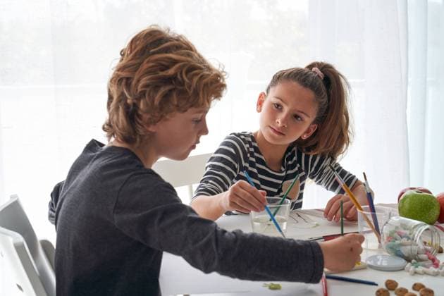 IMAGO Creative: NGO, Kunst im ?ffentlichen Raum und Kulturinitiativen Concentrated girl and boy in casual outfit painting with watercolor while sitting at table at home Copyright: xPhilippexDegrootex Model Released