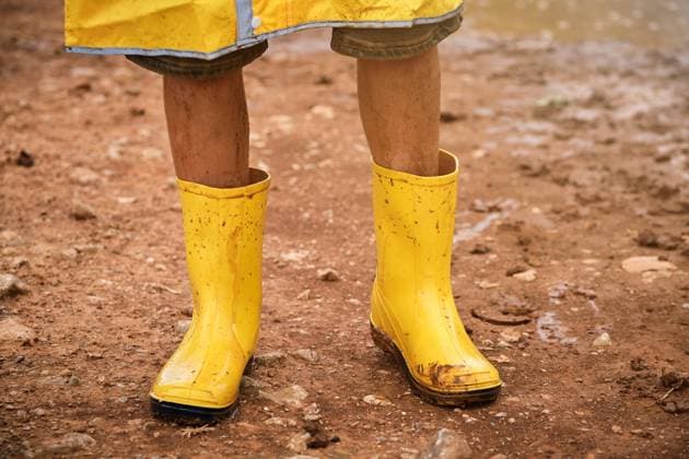 Detail of some legs with yellow dirty muddy water boots in the middle of a path in the forest, Model released Copyright: xPhilippexDegrootex MR