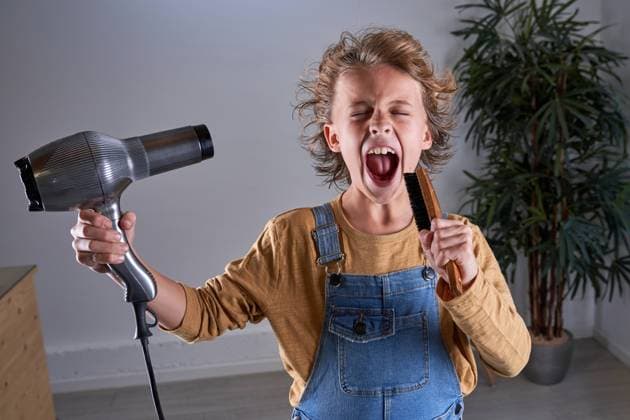 Child in a hairdresser s singing with a hairdryer and a brush Copyright: xPhilippexDegrootex Model Released