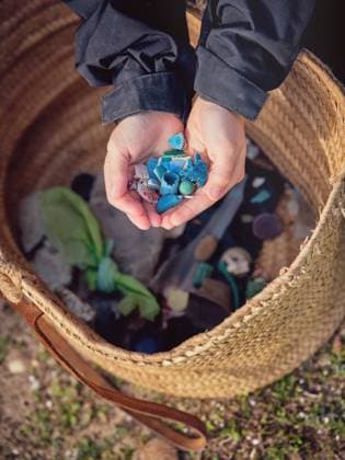 IMAGO Creative: Zivildienst und ehrenamtliches Engagement From above crop hands of teenager with pile of little plastic garbage near container on ground Copyright: xPhilippexDegrootex Model Released