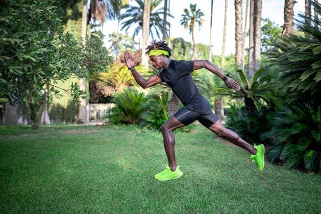 IMAGO Creative: Sport Dichotomien - Land und Wasser Side view of determined young African American male athlete in stylish sportswear running on green lawn in park Copyright: xSergioxVictorxVegax Model Released
