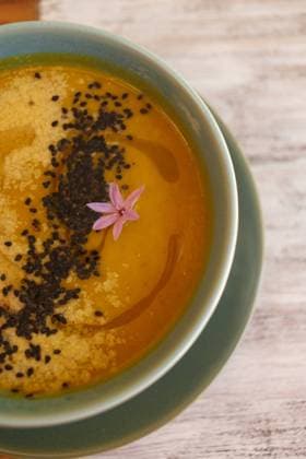 From above yellow soup puree with black seeds in blue bowl, Model released Copyright: xSoniaxAlmudevarx MR
