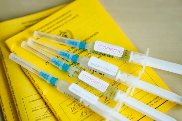 Symbol photo vaccination syringe Biontech and vaccination certificate Symbol photo of Moderna and BIONTECH vaccination syringe on a vaccination certificate Both pharmaceutical companies have currently approved vaccines against the Corona virus Germany