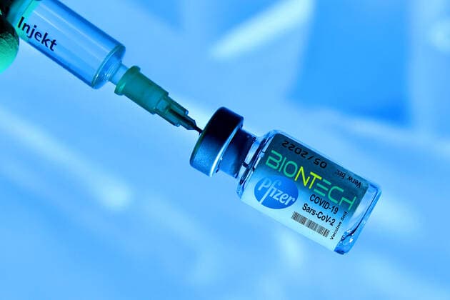 FOTOMONTAGE Theme picture,symbol photo Corona vaccine from Biontech Pfizer before approval in Germany Vaccine syringe and vaccine can with vaccine from the manufacturer Biontech Pfizer against the corona virus Vaccination with disposable syringe and vaccine for injection with a canula