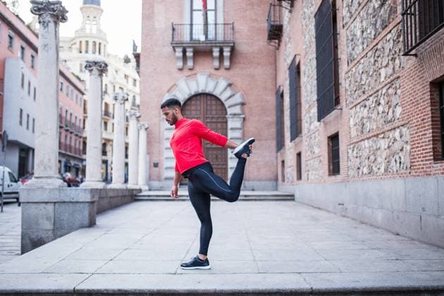 IMAGO Creative: Sport in der Stadt Young man stretching legs in the street Copyright: xWidetapex Model Released