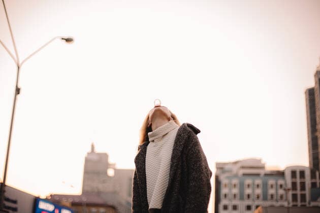 Teenage girl blowing bubble gum against clear sky in city in autumn CR_DMBE201219-571318-01 ,model released, Symbolfoto