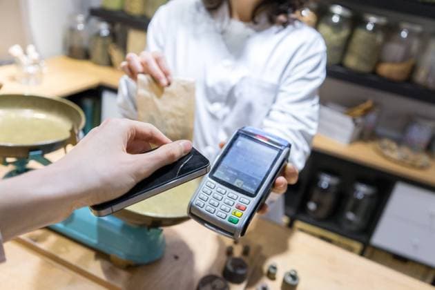 Customer paying with phone in spice shop Copyright: xx Model Released