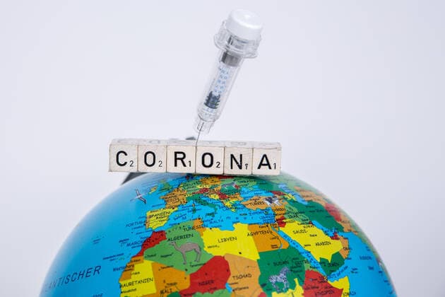 Bamberg, Germany 21 December 2020 A vaccination syringe is stuck in the lettering Corona, which lies on a globe, globe Bayern Copyright: xFotostandx xK.xSchmittx