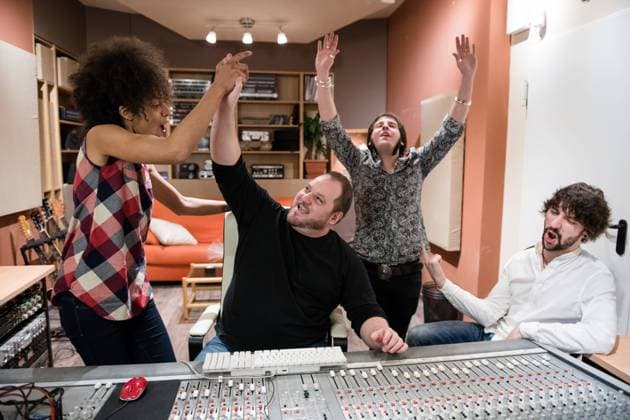 Group of people rejoicing over success and having fun after recording music in studio, Model released, Property released Copyright: xAlvaroxHernandezx MR