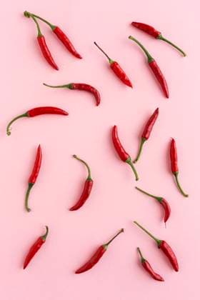 IMAGO Creative, Lifestyle, Barbiecore Red peppers on pink background Copyright: xEduardoxLopezx Model Released