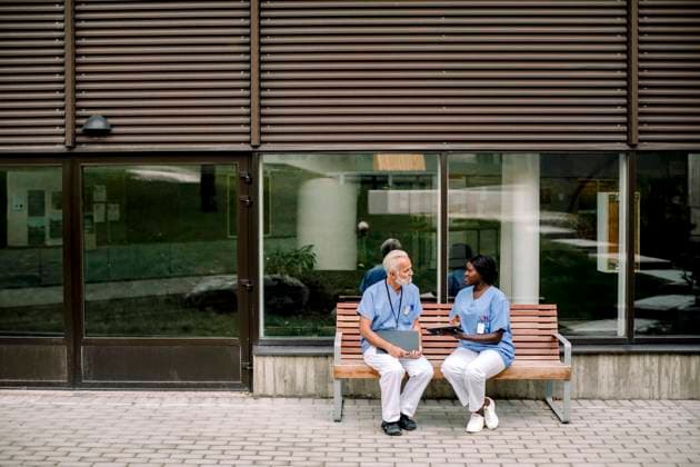 Senior nurse talking to female colleague while sitting on bench Sweden, Stockholm, model released, property released Copyright: xMaskotx , MA83349