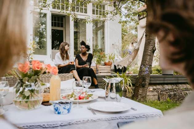 Young women with drinking glass talking while sitting in backyard Sweden, Stockholm, model released, property released Copyright: xMaskotx , MA83457