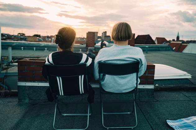 Rear view of friends sitting on chair at building terrace Germany, Berlin, model released, property released Copyright: xMaskotx , MA83601