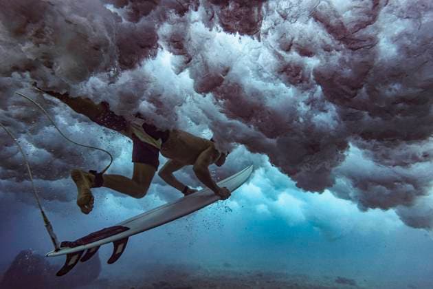 IMAGO Creative: Ruhe im Chaos Male surfer on surfboard diving undersea at Maldives model released Symbolfoto KNTF05979