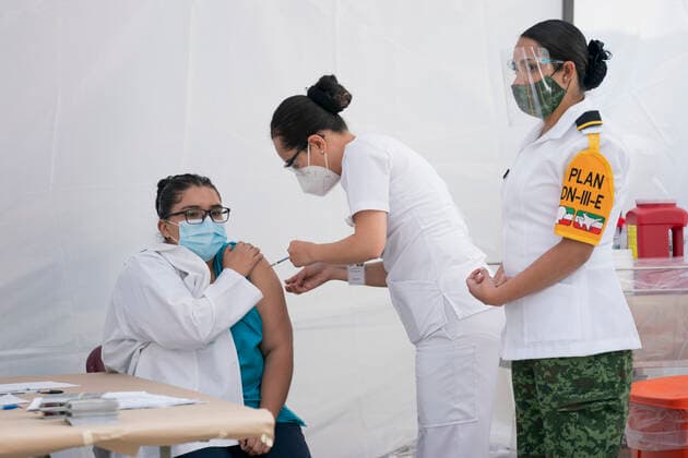 (201224) -- MEXICO CITY, Dec. 24, 2020 -- A medical worker (L) receives a COVID-19 vaccine at the General Hospital in Mexico City, Mexico, on Dec. 24, 2020. Mexico on Thursday kicked off its vaccination campaign against the COVID-19, with a vaccine developed by U.S. laboratory Pfizer and its German partner BioNTech. (Photo by Xinhua) MEXICO-MEXICO CITY-COVID-19-VACCINATION CAMPAIGN LuisxLicona 