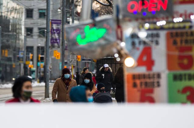 (201228) -- TORONTO, Dec. 28, 2020 -- People wearing face masks walk past a street hot dog cart in Toronto, Ontario, Canada, Dec. 27, 2020. Canada s COVID-19 cases surpassed 550,000, with the total hitting 552,020, including 14,963 deaths, as of Sunday afternoon, according to CTV. Ontario, the most populous province in Canada, reported 2,005 new cases, bringing its total case count to 171,416 on Sunday. (Photo by Xinhua) CANADA-ONTARIO-COVID-19 ZouxZheng