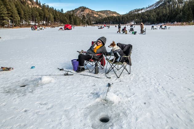 January 2, 2021, Fenton Lake, USA: .People kicked off the new year by going ice fishing at Fenton Lake in the Jemez mountains Saturday morning. This was the first day the lake opened for ice fishing. Due to recent cold weather, the lakes ice thickness is now at minimum standards for this access according to New Mexico State Parks officials. Pictured is Carolyn Snachez(Cq) of Albuquerque with her dog Lenny as they chill while waiting for a catch. Close to 80 folks came out early this morning to try their luck. .Jemez Mountains, New Mexico ABQ Journal Fenton Lake USA - ZUMAab1_ 20210102_zaf_ab1_006 Copyright: xRobertoxE.xRosalesx