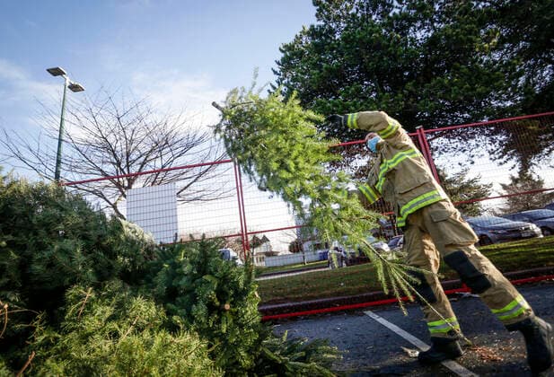(210103) -- RICHMOND (CANADA), Jan. 3, 2021 -- A firefighter collects a Christmas tree at the annual Christmas tree chipping event in Richmond, British Columbia, Canada, on Jan. 3, 2021. Firefighters volunteered to help residents recycle their Christmas trees at the annual tree chipping event. (Photo by Xinhua) CANADA-RICHMOND-FIREFIGHTERS-CHRISTMAS TREE CHIPPING LiangxSen 