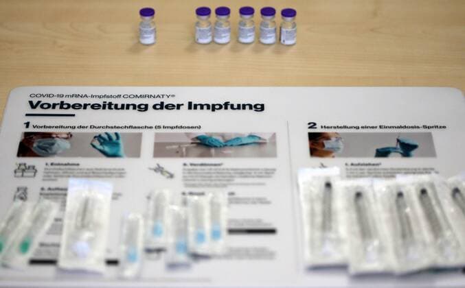 Covid 19 vaccination 07 01 2021, Erfurt, in a retirement home today the staff and the seniors are administered the 1 vaccination with the COVID 19 mRNA vaccine Comirnaty of the company BioNtech Pfizer, in a vial are 5 vaccine doses in the picture information sheet for the preparation of the vaccination, on it lie syringes, behind it is the vaccine in bottles