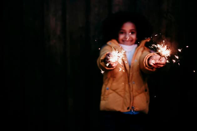 Girl standing and holding burning sparkler at night model released Symbolfoto EBBF01447