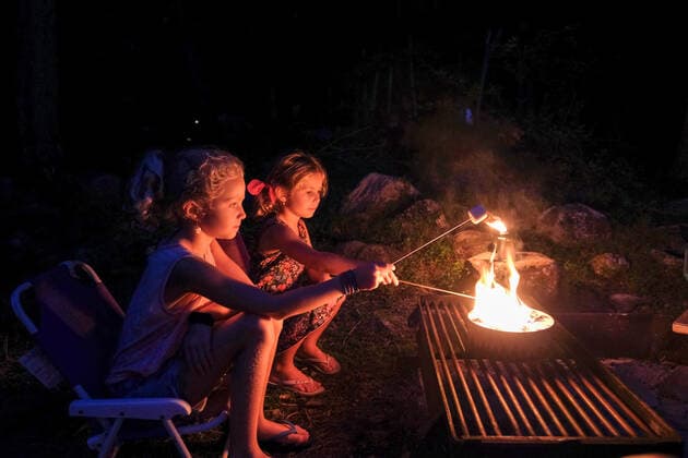 two girls roasting marshmallows over open fire, camping in summertime Harriman, NY, United States CR_STWE210111C-600467-01 ,model released, Symbolfoto