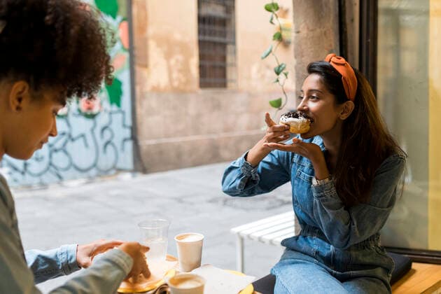 Friends eating food while sitting by window at cafe model released Symbolfoto property released VABF03923