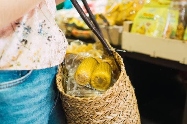 Crop view of anonymous woman holding basket with corn in supermarket, Model released Copyright: xKikexArnaizx MR