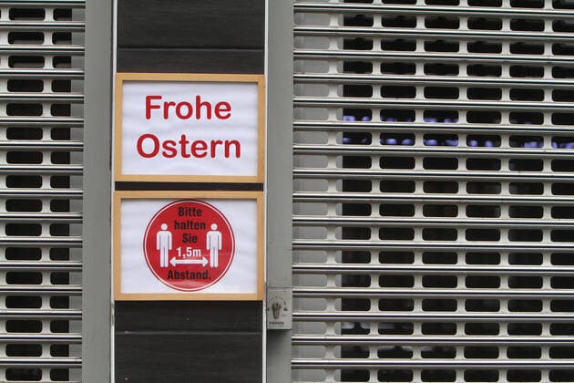 PHOTOMONTAGE Sign with inscription closed until Easter at a shop closed with roller shutter in the city centre of Frankfurt, Hesse, Germany