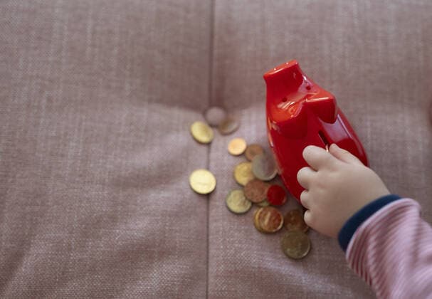 Kind mit einem Sparschwein auf dem Sofa. Bonn Deutschland *** child with a piggy bank on the sofa Bonn Germany Copyright: xUtexGrabowsky photothek.netx