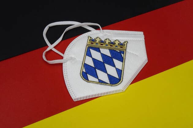 Germany flag with FFP2 mask and coat of arms Germany flag with FFP2 mask and coat of arms, 14 01 2021, Borkwalde, Brandenburg, On a Germany flag lies a FFP 2 mask with the coat of arms of Bavaria