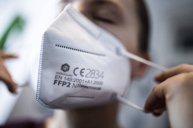 A woman puts on a FFP2 mask, taken in Berlin, 15 01 2021 Due to the still spreading Corona virus there is a discussion about a general obligation to wear a FFP2 mask Berlin Germany Copyright: xFlorianxGaertner photothek.dex