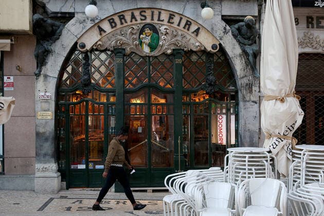 January 15, 2021, Lisbon, Portugal: A woman wearing a face mask walks by A Brasileira coffee shop on the first day of the second national lockdown to combat the COVID-19 Coronavirus pandemic in Lisbon, Portugal on January 15, 2021. Portuguese Prime Minister Antonio Costa announced last Wednesday a new confinement between January 15 and 30 with the same restrictive measures of March and April 2020, with the only relevant new exception that is schools will remain in full operation. Lisbon Portugal - ZUMAf123 20210115_zap_f123_025 Copyright: xPedroxFiuzax
