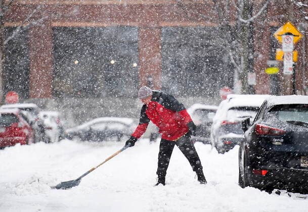 January 16, 2021, Montreal, PQ, Canada: A man clears snow from around his car during a snowstorm in Montreal on Saturday January 16, 2021. Montreal Canada  - ZUMAc35_ 20210116_zaf_c35_002 Copyright: xGrahamxHughesx
