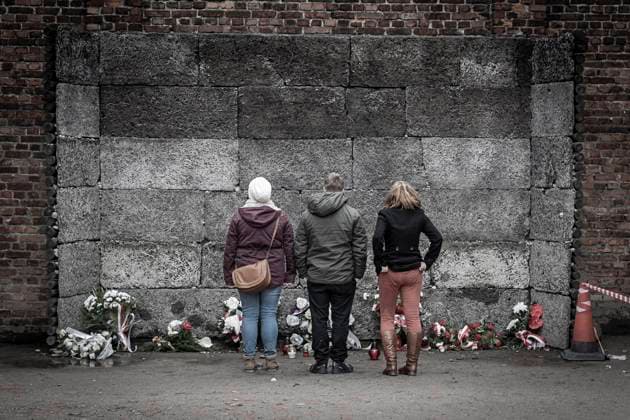 30 11 2018, xovx, politics, current affairs, history, Auschwitz concentration camp, Poland 3 youths at the memorial site ÒWall of Death,Ó where the shootings of prisoners took place, in the courtyard between Block 10 and Block 11 at Auschwitz I main concentration camp , Auschwitz Oswiecim Lesser Poland Voivodeship Poland